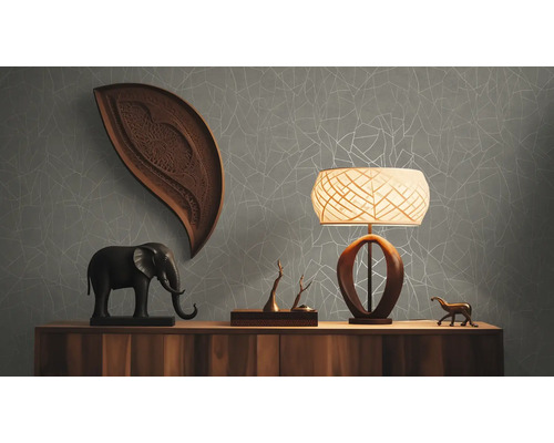 Woonkamer met dressoir, lamp en decoraties tegen een grijs behang met patroon