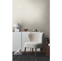 Woonkamer met structuurbehang, fauteuil, dressoir en decoratie