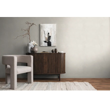 Lichte woonkamer met fauteuil, dressoir, abstracte kunst en decoraties