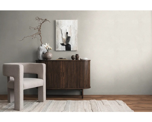 Lichte woonkamer met fauteuil, dressoir, abstracte kunst en decoraties