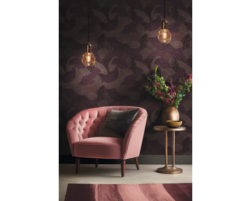 Woonkamer met fauteuil, bijzettafel, hanglampen en behang met motief