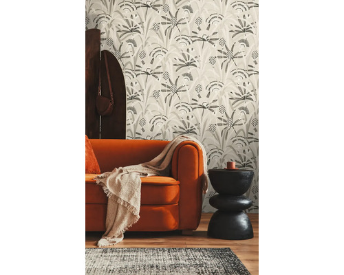 Woonkamer met oranje bank, gedessineerd behang en zwarte bijzettafel