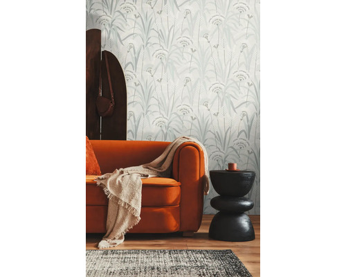 Woonkamer met behangmotief, bank en bijzettafel.