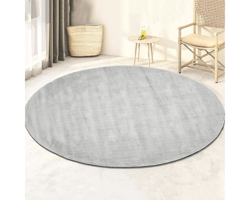 Rond vloerkleed in de woonkamer met mand, tafel en stoel