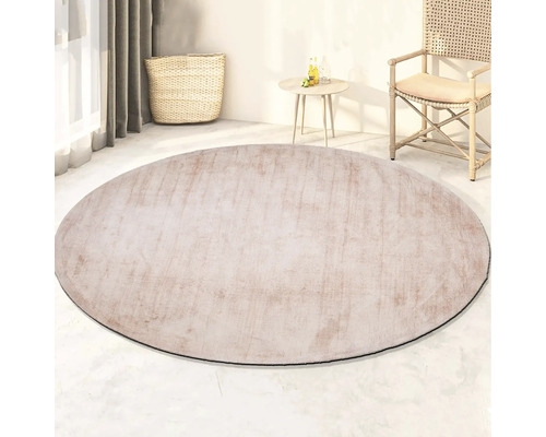 Rond vloerkleed in woonkamer met stoel, tafel en mand