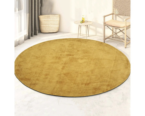 Rond vloerkleed in woonkamer met rotan stoel en bijzettafel