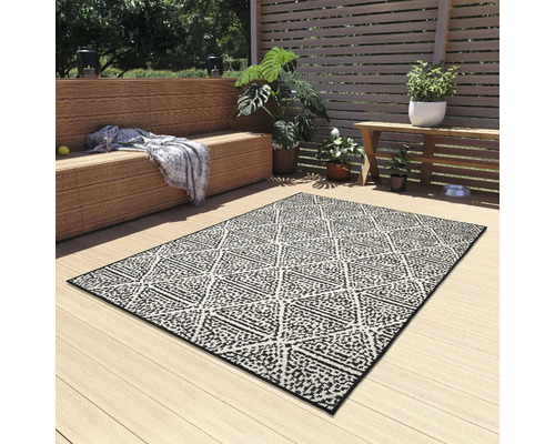 Terras met buitentapijt met geometrisch patroon, zitbank en planten