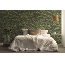 Slaapkamer met bed, nachtkastje, lamp en mosbehang