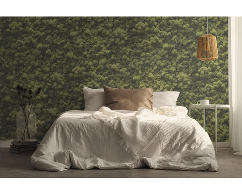 Slaapkamer met bed, nachtkastje, lamp en mosbehang