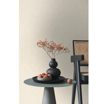 Decoratieve interieurscène met een kleine tafel, vaas, droogbloemen en fruit naast een stoel.