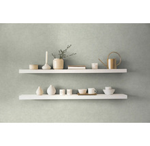 Twee witte planken aan een muur gedecoreerd met vazen, een kaars, een gieter en servies