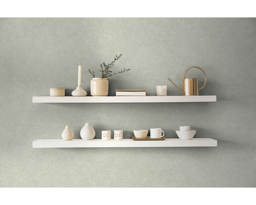 Twee witte planken aan een muur gedecoreerd met vazen, een kaars, een gieter en servies