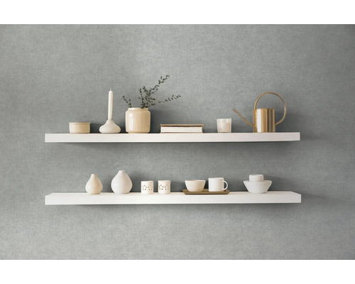 Decoratieve witte wandplanken met vazen, bekers en een gieter