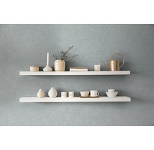 Twee witte wandplanken met decoratieve items aan een muur
