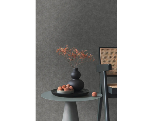 Close-up van een tafel met decoratie voor een donkerkleurig wandbehang.