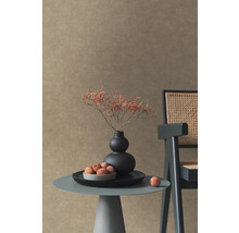 Decoratieve scène met tafel, vaas, droogbloemen en stoel voor een wand