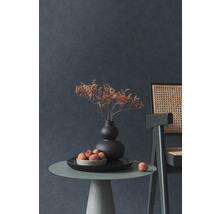 Decoratief stilleven met droogbloemen in vaas, fruitschaal en stoel op een bijzettafel tegen een donkere wand