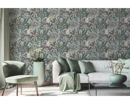 Woonkamer met behang met patroon van kaketoes en plantenmotieven, bank en stoel.