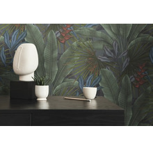 Decoratieve kamer met botanisch behang, sculptuur, plant en potlood op een donkere tafel.