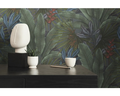 Decoratieve kamer met botanisch behang, sculptuur, plant en potlood op een donkere tafel.