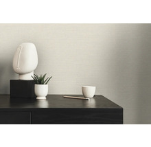 Scene met textielbehang, tafel, sculptuur en plant