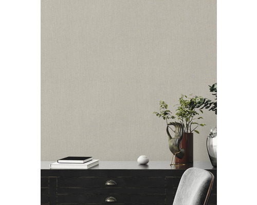 Close-up van een gestructureerd behang in een kamer met dressoir, boeken en plantdecoratie