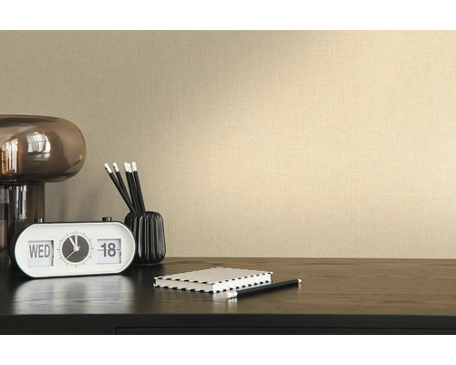 Close-up van een beige vliesbehang met textielstructuur op een muur