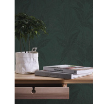 Decoratief behang met plantenmotief achter plant en boeken op een houten tafel