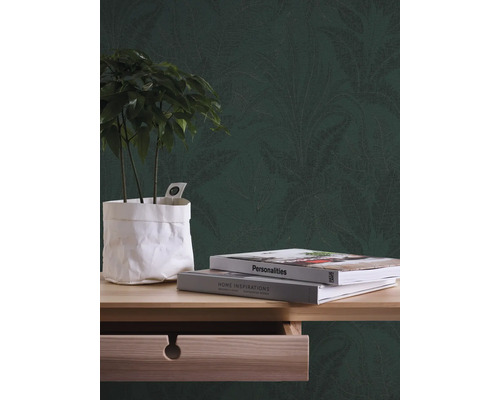 Decoratief behang met plantenmotief achter plant en boeken op een houten tafel