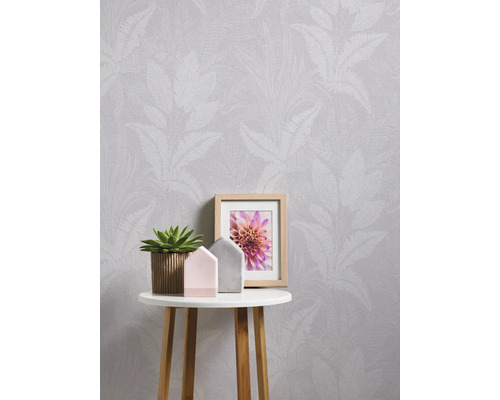 Behang met bladerenmotief op een tafel met decoratie