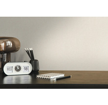Detailopname van een beige behang met bureau en accessoires