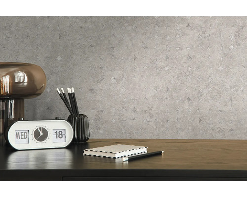 Close-up van een grijs patroonbehang met een bureau en accessoires