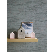 Close-up van een gestructureerd behang met decoratieve items op een plank.