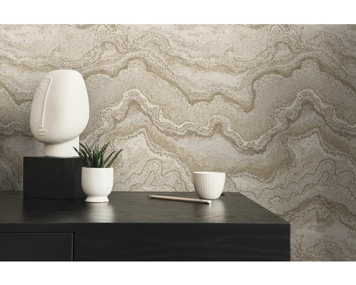 Decoratieve opstelling met vliesbehang in marmerlook, sculptuur, plant en schaal op een tafel