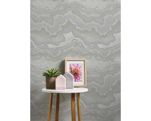 Woonkamer met behang met patroon, tafel, plant en fotolijst