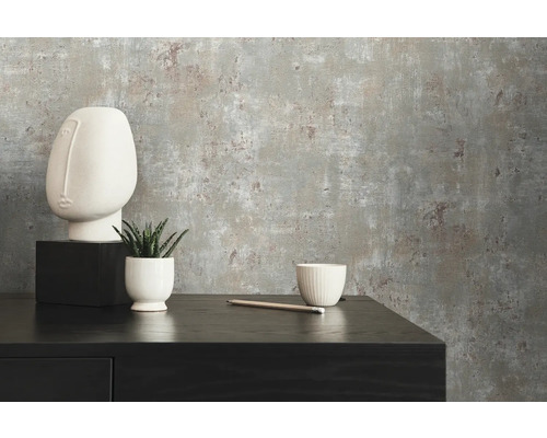 Close-up van een grijs betonstructuurbehang met minimalistische decoratie op een zwart dressoir.