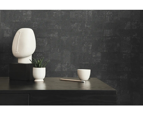 Close-up van een kamer met een zwarte commode, een witte buste, een plant, een beker en een potlooddecoratie voor een donkere muur