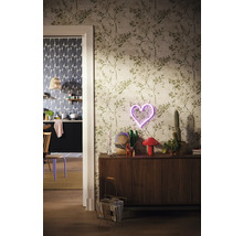 Woonkamer met behang met plantenmotief, dressoir, neonhart en decoratie