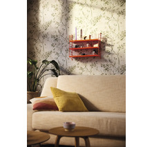 Woonkamer met bank, houten tafel, potplant, wandrek en behang met bladmotief