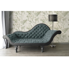 Chaise longue met knoopsluiting voor een bloemig behang en een staande lamp