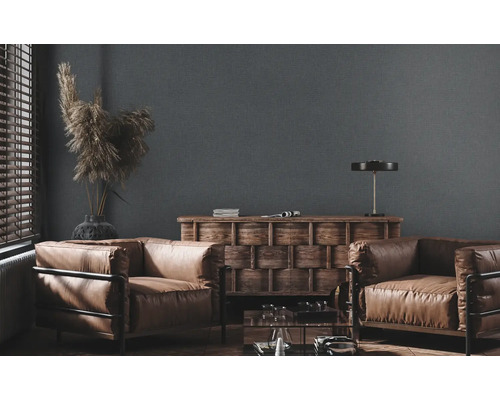 Woonkamer met twee fauteuils, een houten tafel en decoratie