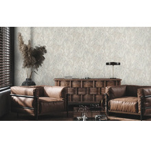 Woonkamer met bruine leren fauteuils en behang met plantenmotief