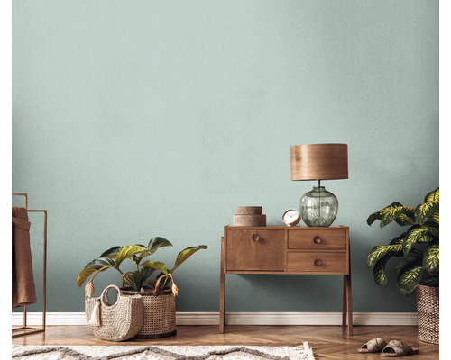 Woonkamer met houten vloer, commode, lamp, planten en vloerkleed