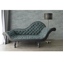 Chaise longue met knoopsluiting en staande lamp in een woonkamer