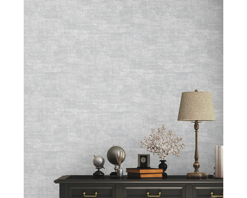 Close-up van een muur met een grijs textielbehang met een subtiele textuur.