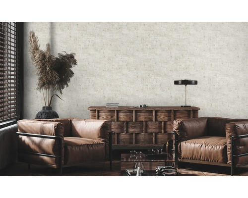 Woonkamer met twee leren fauteuils, houten dressoir en een behang met patroon