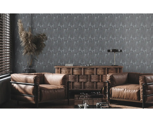 Woonkamer met grijs behang, twee bruine lederen fauteuils en een houten dressoir