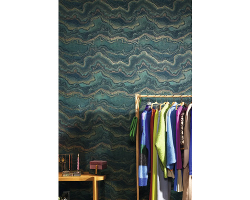 Woonkameropstelling met een groen vliesbehang met golfpatroon, kledingrek en accessoires