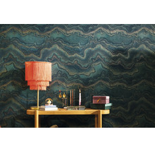 Scene met patroonbehang, tafel en decoratieve objecten zoals een lamp, sieradenstandaard en kaars