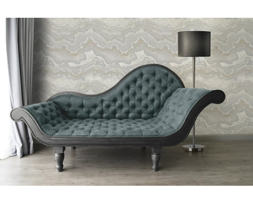 Chaise longue met knoophechting en staande lamp voor een patroonbehang